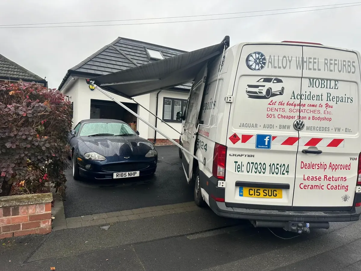 Jaguar on a driveway next to the mobile repair van